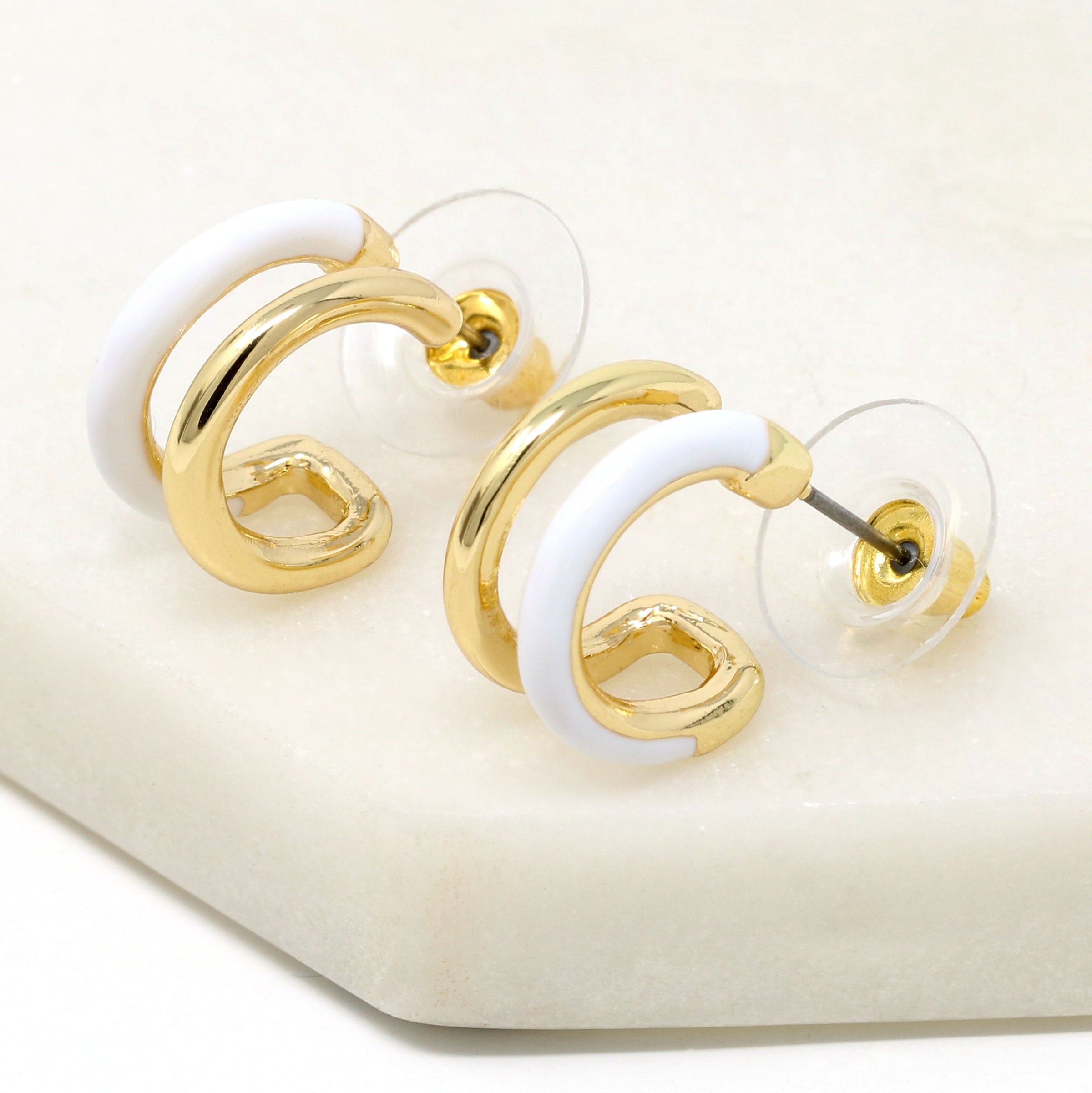 Double hoop earrings featuring white and metal hoops for a bold and stylish look.