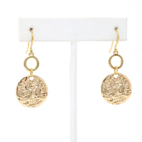 A pair of hammered charm drop and dangle earrings in gold.