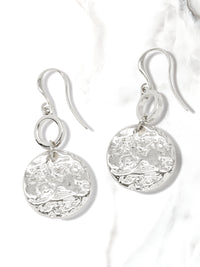 A pair of hammered charm drop and dangle earrings in silver.