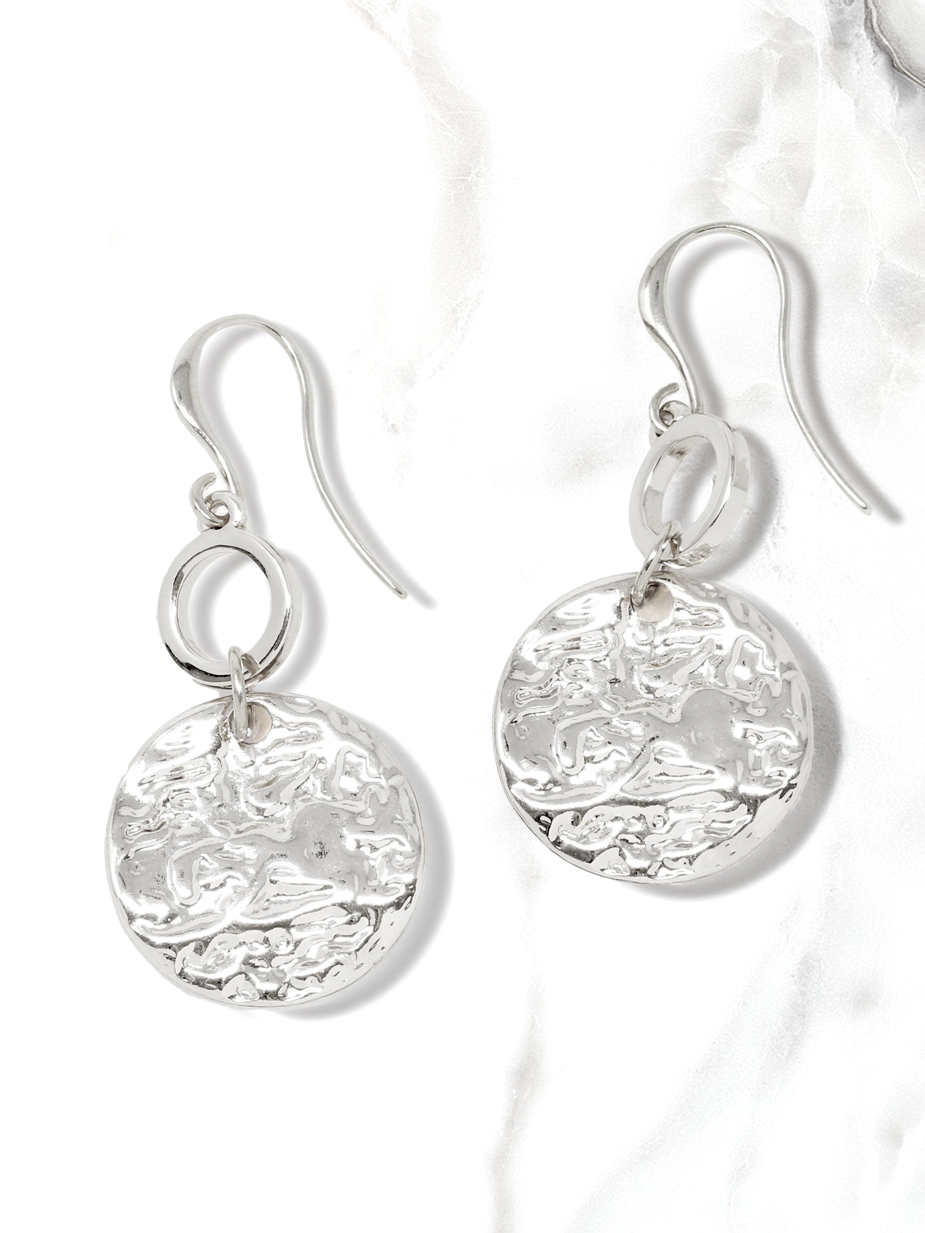 A pair of hammered charm drop and dangle earrings in silver.