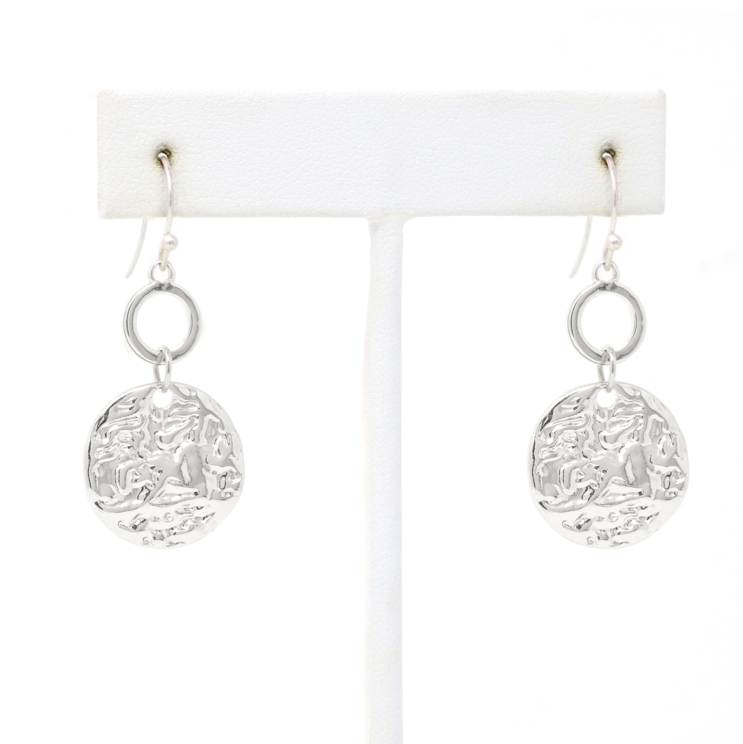 A pair of hammered charm drop and dangle earrings in silver.