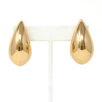 A close-up of gold puffy teardrop hollow bold earrings, showcasing their modern and minimalist design. The earrings make a statement with their sleek metal construction and distinctive shape.