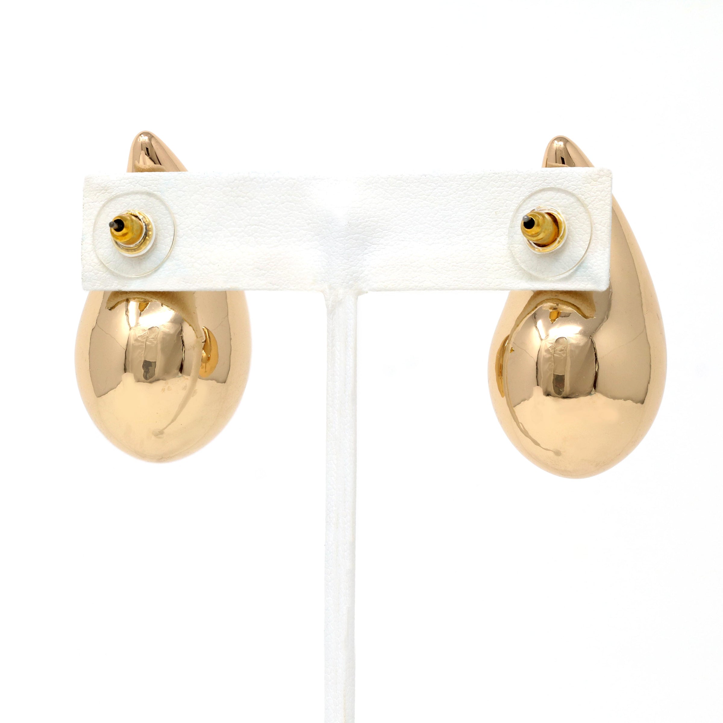 A close-up of gold puffy teardrop hollow bold earrings, showcasing their modern and minimalist design. The earrings make a statement with their sleek metal construction and distinctive shape.
