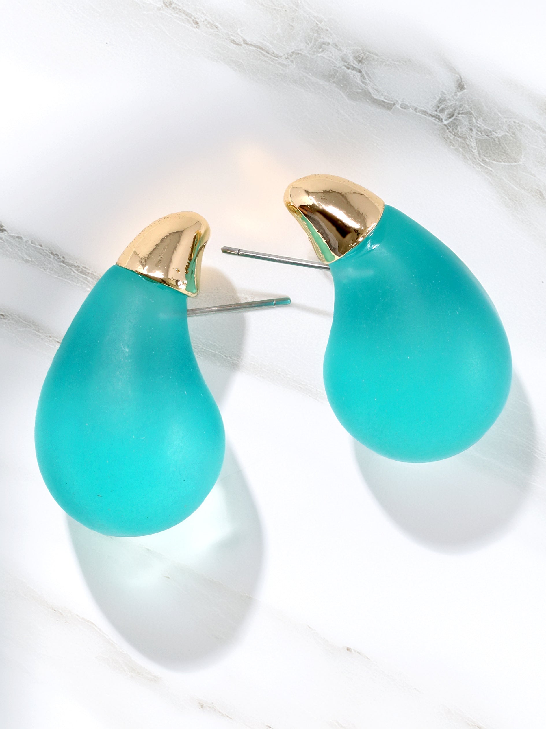 Frosted and clear teardrop stud earrings in blue with gold tips.