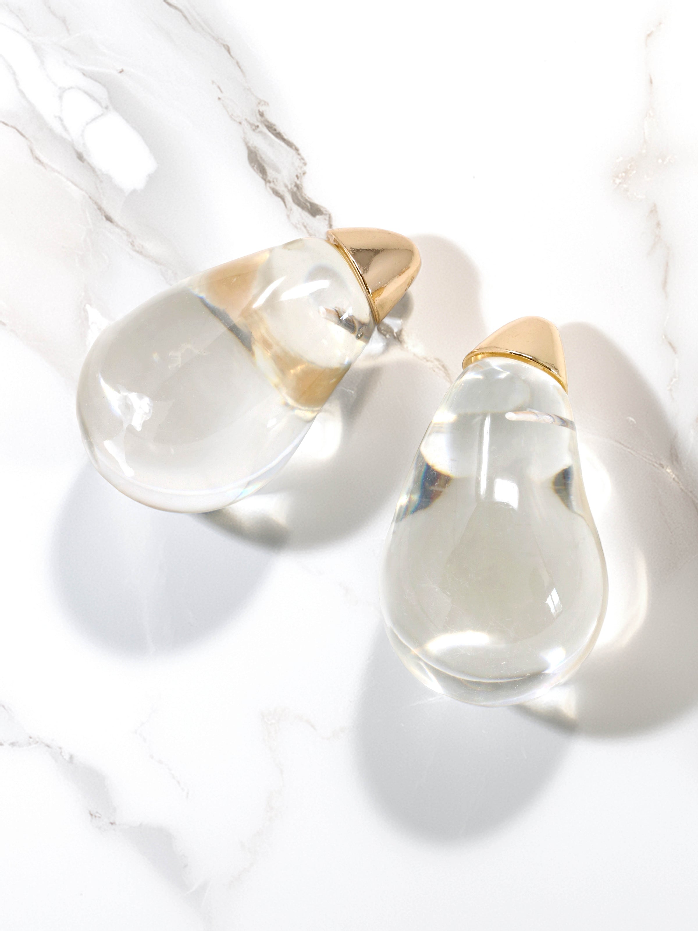 Clear lucite puffy teardrop earrings feature sleek and polished transparent resin teardrops that catch the light beautifully.