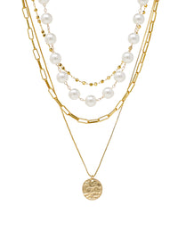4-layer necklace featuring paperclip chain links, white pearls, gold bead accents, and a hammered coin pendant.