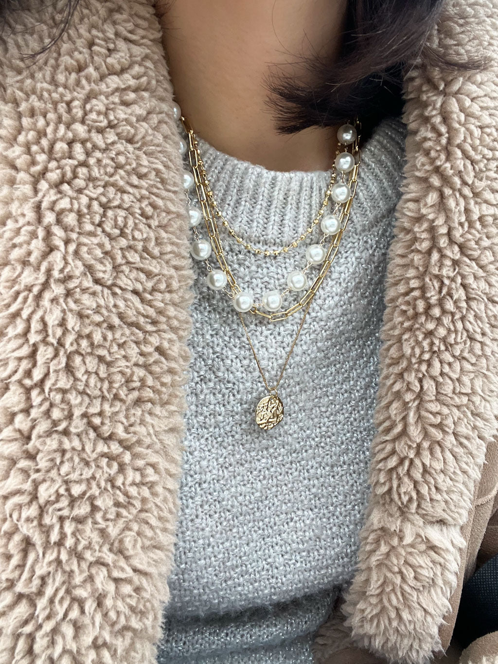 4-layer necklace featuring paperclip chain links, white pearls, gold bead accents, and a hammered coin pendant.