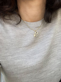 Script initial letter charm necklace dangled in a gold-filled paperclip chain.