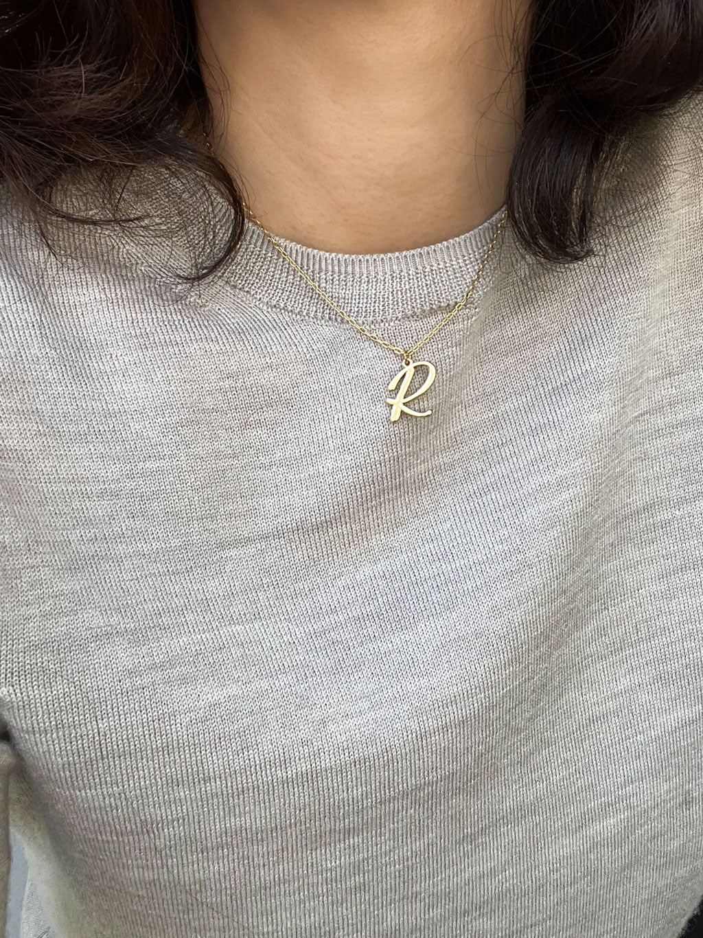 Script initial letter charm necklace dangled in a gold-filled paperclip chain.