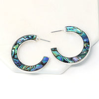 A pair of metal-mounted natural abalone shell hoop earrings. The iridescent abalone shells display beautiful shades of blue, green, black and purple, with a unique natural pattern visible from both sides.