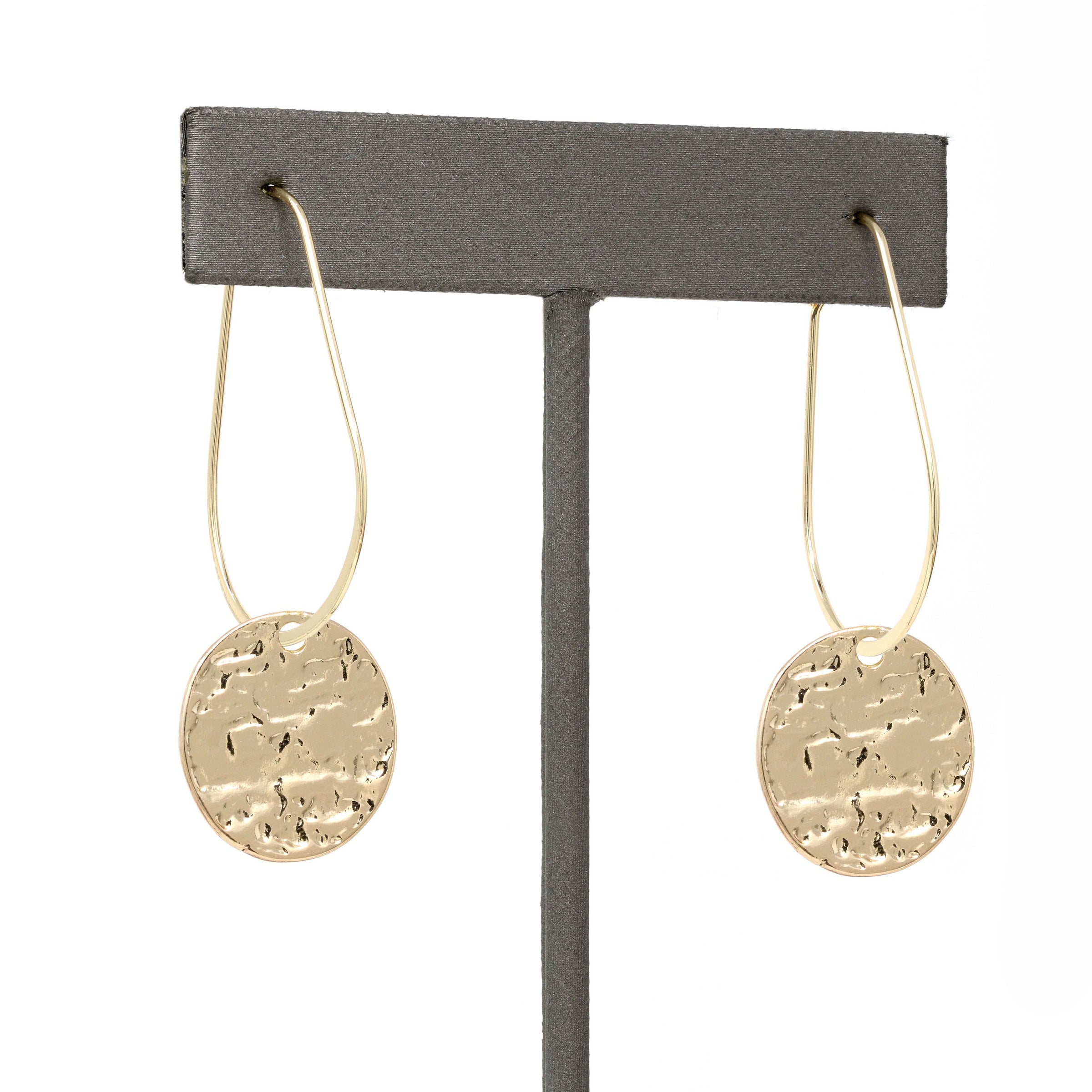 Lightweight metal hoop earrings in gold with small hammered circle charms.
