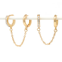 Paved modern loop earplug earrings in gold connected with chains.