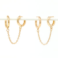 Modern loop earplug earrings in gold, connected with chains.