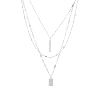 A modern triple-layered necklace in silver dangled with two bar charms.