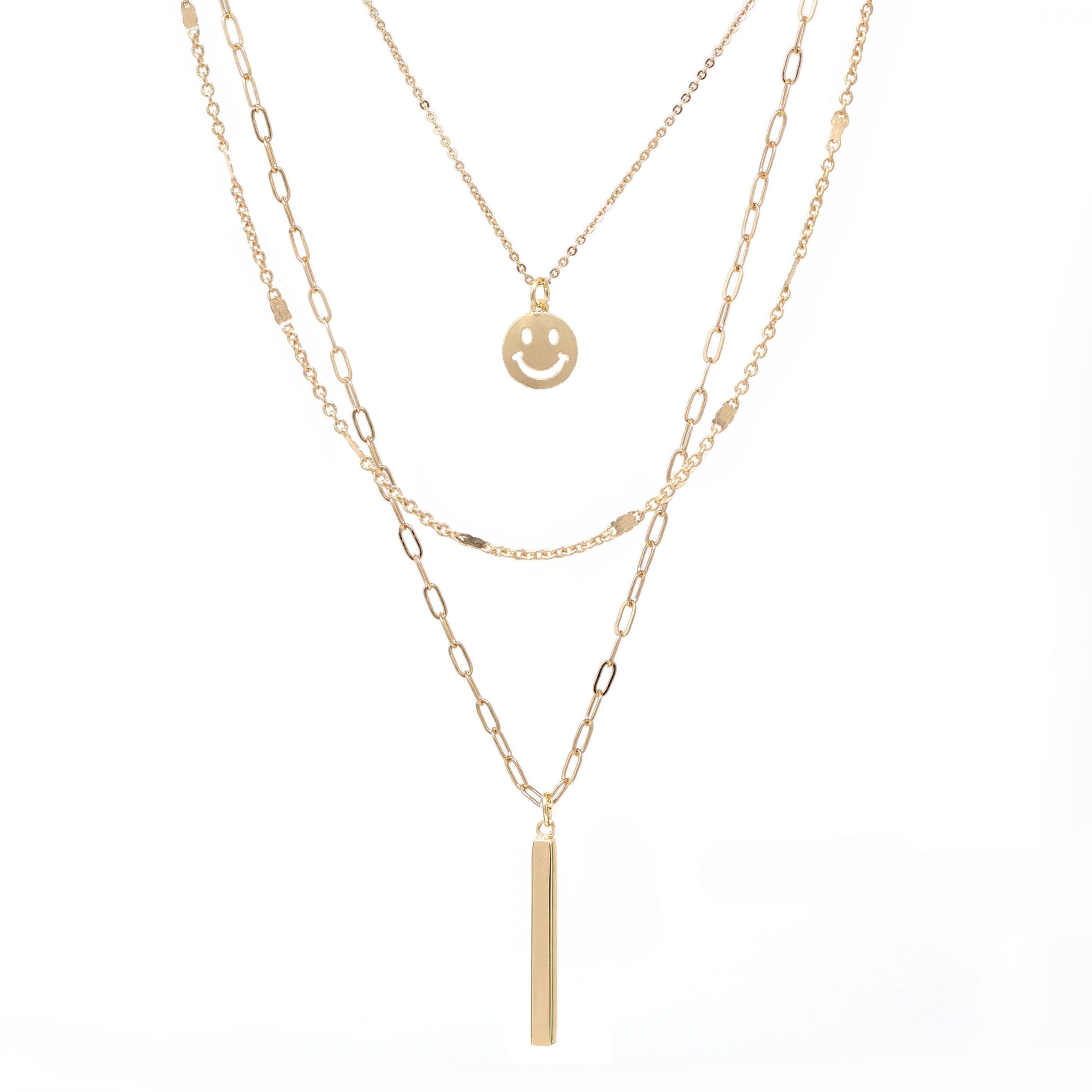 A set of triple layered necklace in gold with a small smiley face and a skinny bar charms.