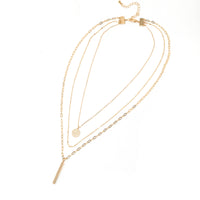 A set of triple layered necklace in gold with a small smiley face and a skinny bar charms.