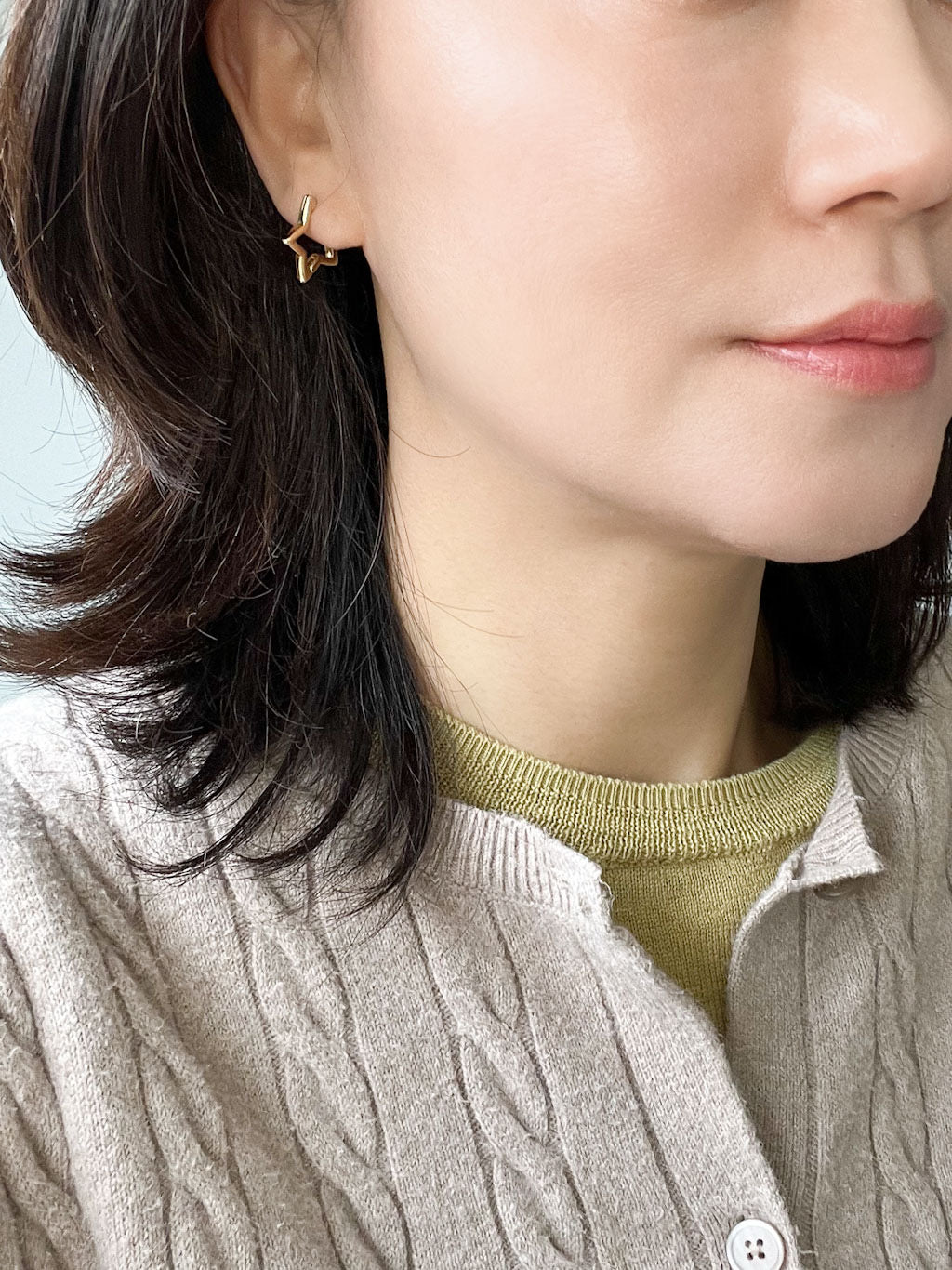 A pair of modern star huggie earrings in gold.