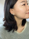 A pair of gold-tone textured puffy heart stud earrings with a delicate, intricate surface pattern.