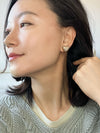 A pair of gold-tone textured puffy heart stud earrings with a delicate, intricate surface pattern.