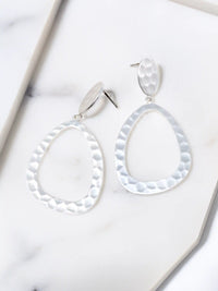 Pair of silver hoop earrings on a marble surface