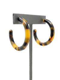 Brown tortoise resin hoop earrings with a marbled pattern of beige, brown, and black.