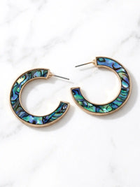 Natural abalone shell hoop earrings with iridescent blue, green, purple and black tones on gold hoops.