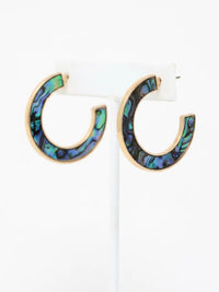 Natural abalone shell hoop earrings with iridescent blue, green, purple and black tones on gold hoops.