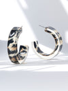 Pair of hoop earrings with a tortoiseshell pattern on a light background