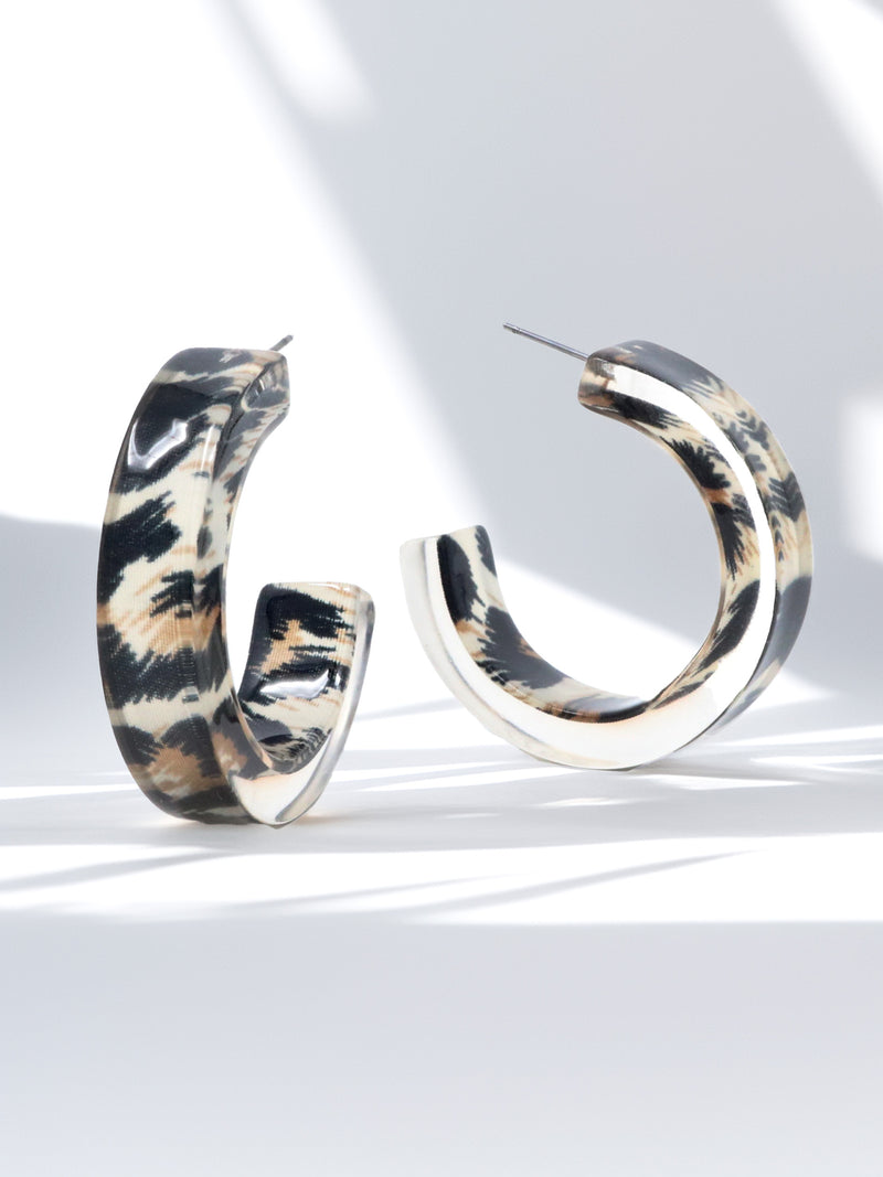 Pair of hoop earrings with a tortoiseshell pattern on a light background