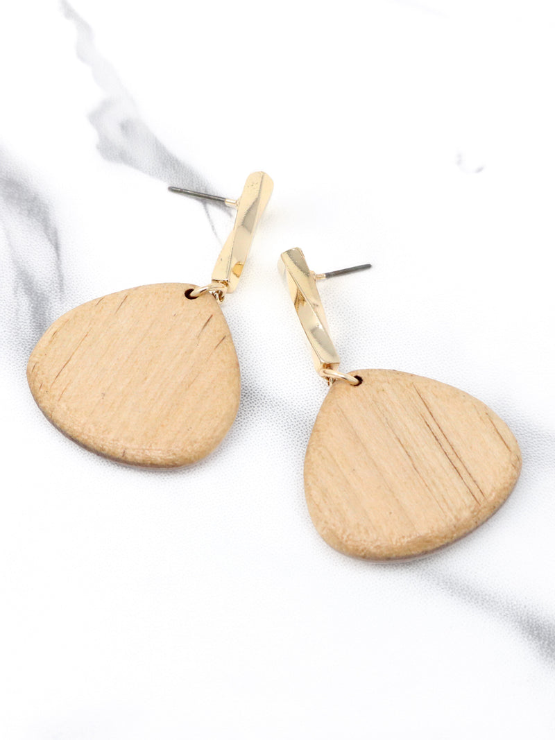 Pair of gold earrings on a white fabric background