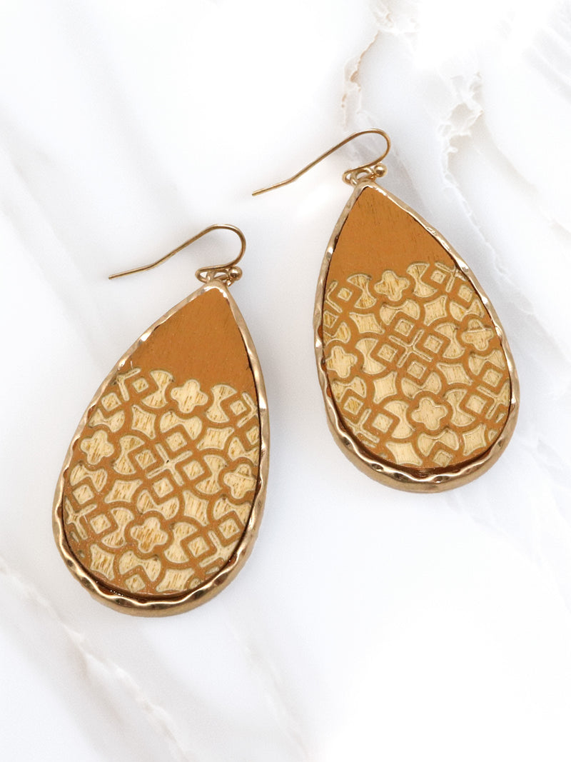 Gold teardrop earrings with intricate patterns on a white background