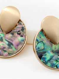 A close up of gold-tone round disc stud earrings with colorful iridescent abalone shell inlay in blue, green, and pink by Bauble Sky