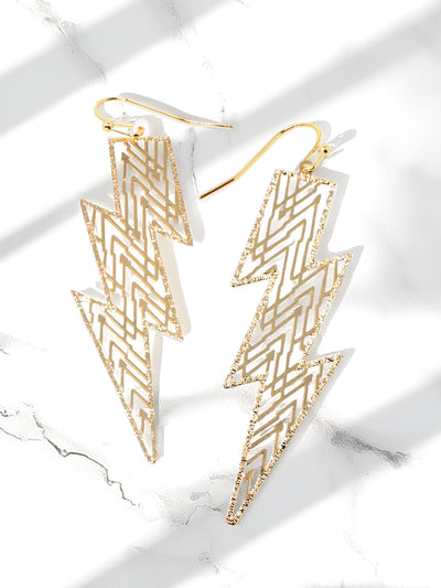 Gold lightning bolt earrings on a marble surface