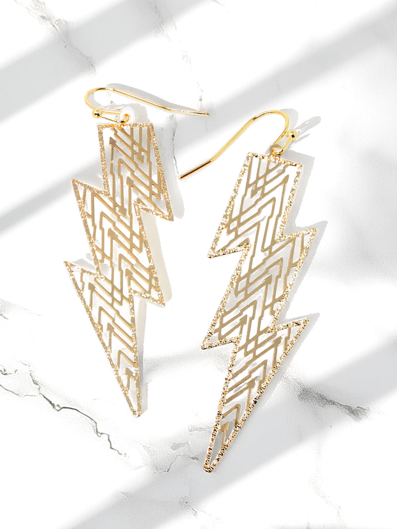 Gold lightning bolt earrings on a marble surface