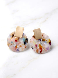 Colorful round earrings with gold posts on a white background