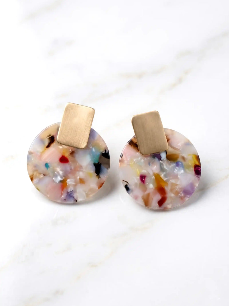 Pair of earrings with colorful circular stones and gold posts on a light background