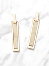 Gold bar earrings on a marble background