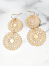 Gold circular earrings on a marble surface