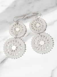 Silver beaded earrings on a marble surface