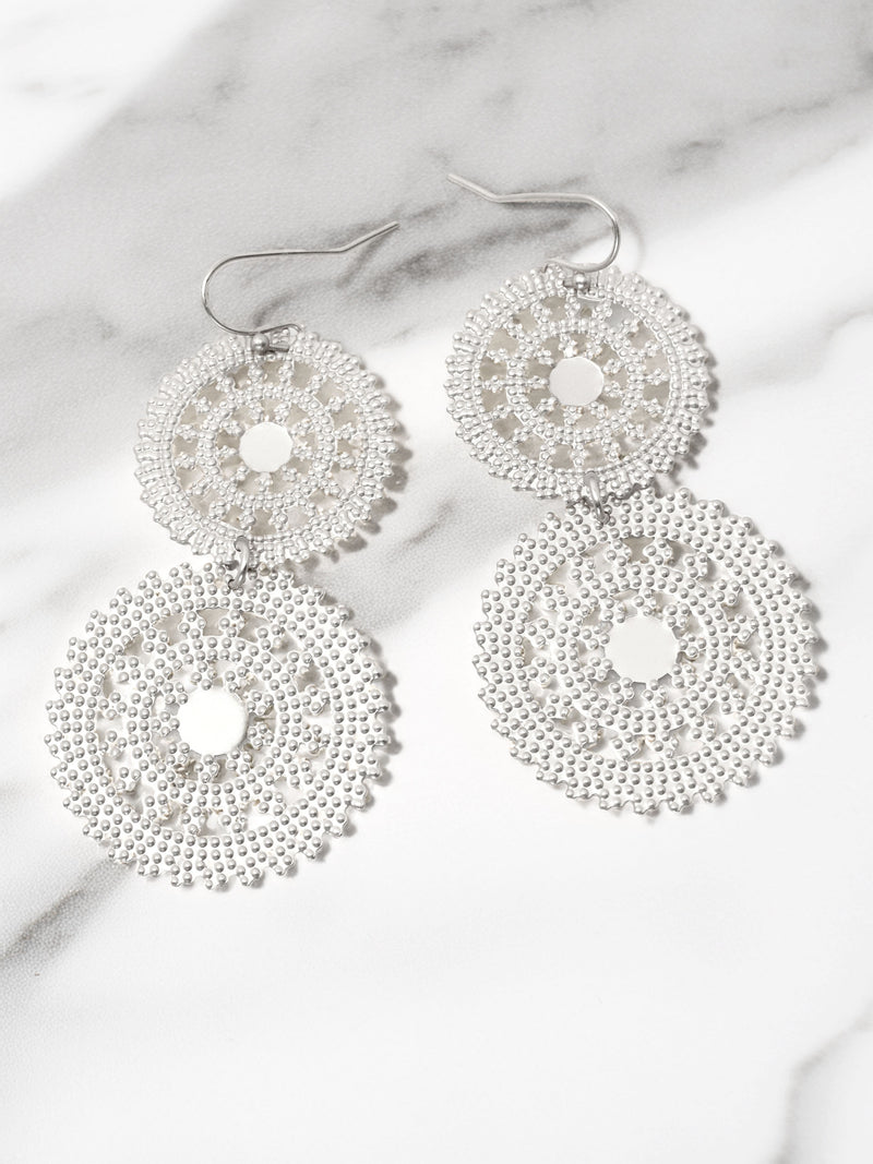Silver beaded earrings on a marble surface