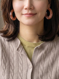 A pair of chunky, open C-shaped resin hoop earrings featuring a swirled brown and white marbled pattern.