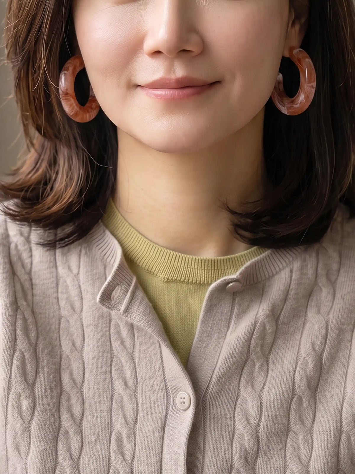 A pair of chunky, open C-shaped resin hoop earrings featuring a swirled brown and white marbled pattern.
