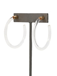 Pair of clear Lucite hoop earrings by Bauble Sky featuring polished transparent resin, gold-tone accents, and a modern minimalist design.