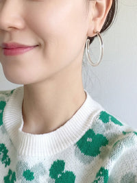 Pair of clear Lucite hoop earrings by Bauble Sky featuring polished transparent resin, gold-tone accents, and a modern minimalist design.
