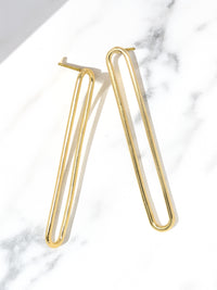 Gold hoop earrings on a marble surface