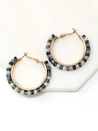 Pair of hoop earrings with beaded accents on a white surface