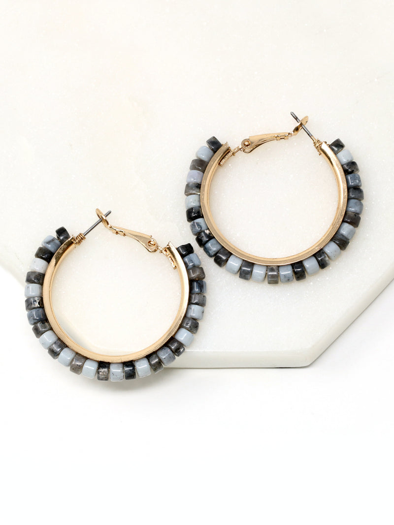 Pair of hoop earrings with beaded accents on a white surface