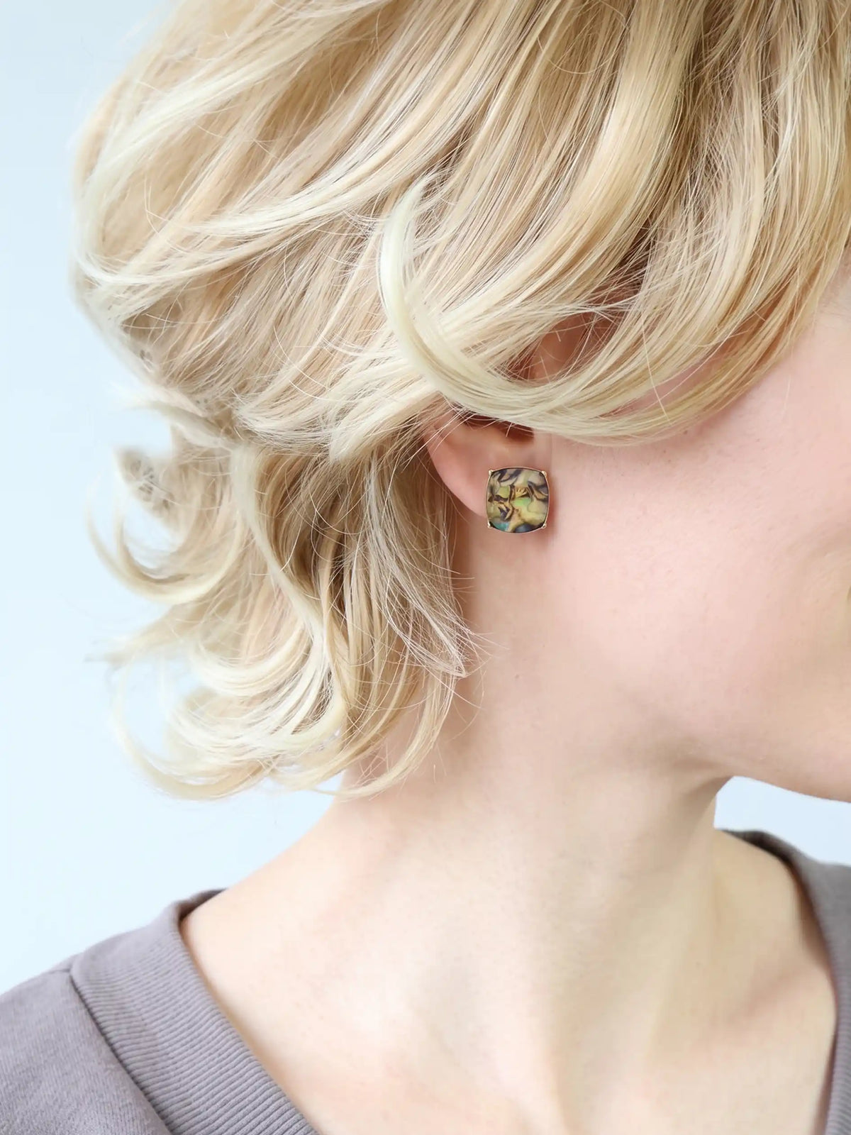 Natural abalone shell stud earrings with iridescent colors and faceted clear stones, available in gold.