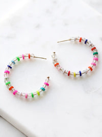 Lightweight clear glass beaded hoop earrings with multicolored rubber bead accents and gold-tone details by Bauble Sky.