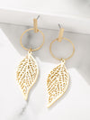 Gold leaf-shaped earrings on a white surface